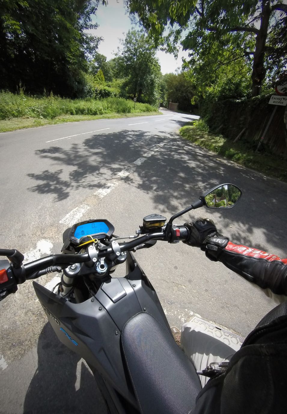 electric motorcyclist waiting at country road junction